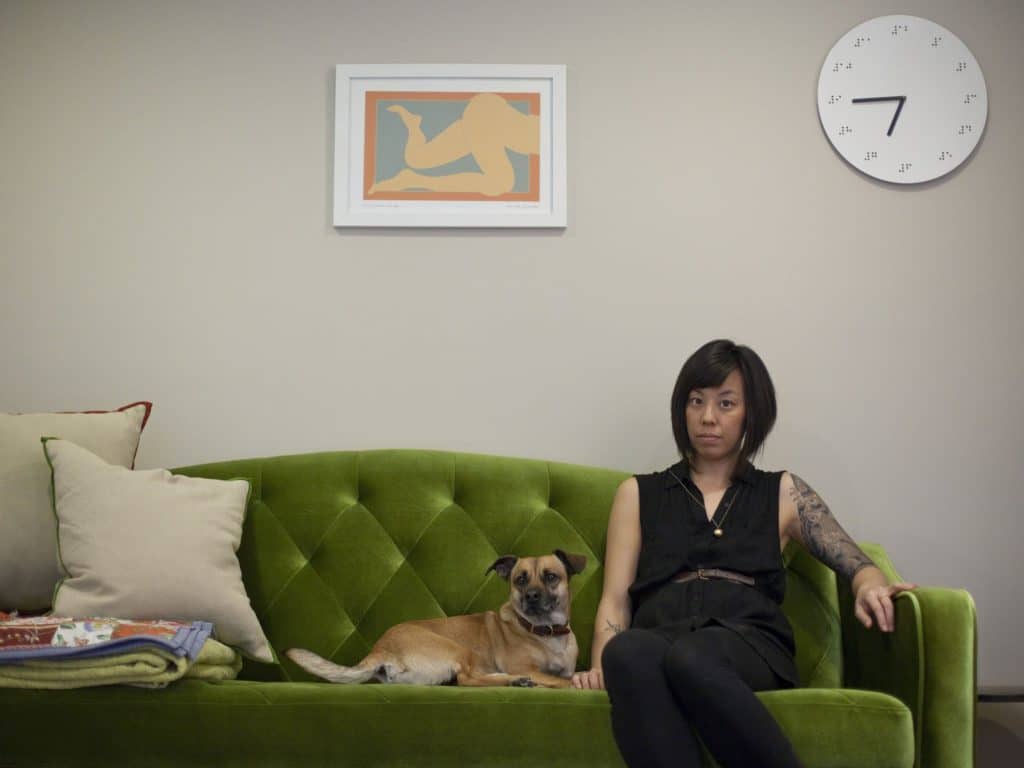 Graphic designer Kaleena Porter sits with her dog, Moby, in the living room of her new home in Washington, D.C.